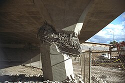 A collapsed concrete bridge, with a broken support pier