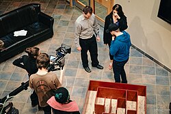 Film crew and cast members working together during principal photography