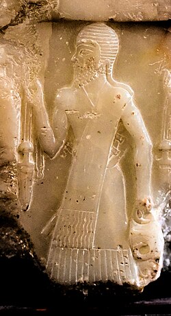Akkadian soldier of Naram-Sin, with helmet and long sword, on the Nasiriyah stele. He carries a metal vessel of Anatolian type. From Mesopotamia, Iraq, c. 2300 BC. Iraq Museum.[59]
