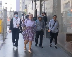 Rubashkyn (front) gesturing a V sign outside of Auckland District Court in 2024