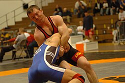 A freestyle wrestler locks the arms of his opponent in order to take him down to the mat