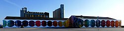 A 90 meter long mural on a wall at a parking lot in Ystad Sweden in 2024.