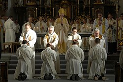 Priests lay their hands on the ordinands during the rite of ordination.
