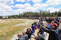 Tourists watch Old Faithful erupt, 2019