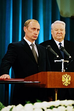 Vladimir Putin takes the oath of office as president on his first inauguration, with Boris Yeltsin looking over, 2000