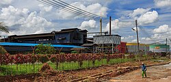 A worker walking near the border of an oil mill in Malaysia. Palm oil production is an important part of economies in many parts of rural Malaysia, but is also a source of environmental conflict.