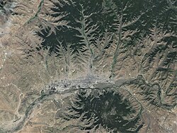 Satellite image of Ulaanbaatar, showing the city core along the Tuul River Valley with Bogd Khan Mountain dominating the south. The city's ger districts sprawl into the mountainous areas in the north.