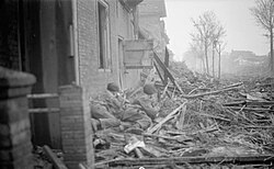Two British Marine Commandos take protection behind debris during the capture of Walcheren Island during World War II. The link between war and democratization has been a focus of some theories.