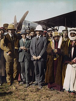 Sir Herbert Samuel (centre), with T. E. Lawrence (in homburg hat), Sheik Majid Pasha el Adwan (at far right) and Gertrude Bell (at left) at the aerodrome of Amman, April 1921
