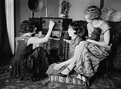 Around 1920, radio broadcasting started to get popular. The Brox Sisters, a popular singing group, gathered around the radio at the time.