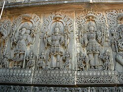Temple wall panel relief sculpture at the Hoysaleswara Temple in Halebidu, representing the Trimurti: Brahma, Shiva and Vishnu
