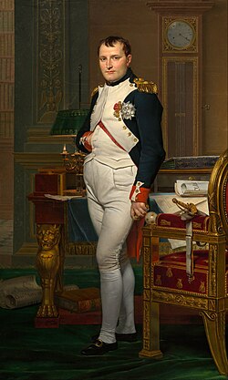Full-length portrait of a man in his forties, in high-ranking dress white and dark blue military uniform. He stands amid rich 18th-century furniture laden with papers, and gazes at the viewer. His hair is Brutus style, cropped close but with a short fringe in front, and his right hand is tucked in his waistcoat.