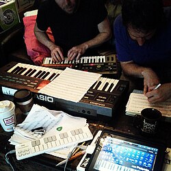 People composing music in 2013 using electronic keyboards and computers