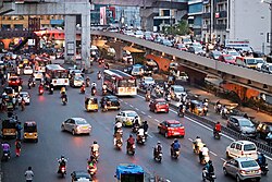 A scene from a Hyderabad street shows—Public transport busses operated by TSRTC, Auto rickshaw, private cars and bikes, on the right—Traffic congestion over the Begumpet Flyover bridge.