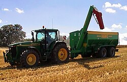 A tractor pulling a chaser bin