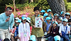 Park (center) smiles and shows a portrait drawn by a girl in Cheong Wa Dae, Seoul, at Children's Day 5 May 2013