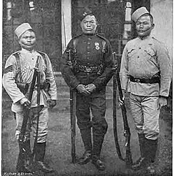 Gurkha soldiers (1896). The centre figure wears the dark green dress uniform worn by all Gurkhas in British service, with certain regimental distinctions.