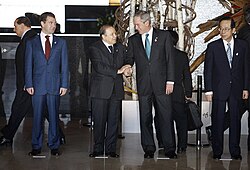 President Abdelaziz Bouteflika and George W. Bush exchange handshakes at the Windsor Hotel Toya Resort and Spa in Tōyako Town, Abuta District, Hokkaidō in 2008. With them are Dmitriy Medvedev, left, and Yasuo Fukuda, right.