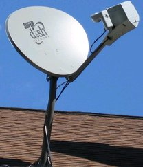 One use of the band is direct-broadcast satellite television. A satellite dish on a residence, which receives satellite television channels over a Ku band microwave beam from a broadcast communications satellite in a geostationary orbit 35,700 kilometres (22,000 miles) above the Earth.