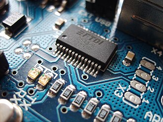 Modern surface-mount electronic components on a printed circuit board, with a large integrated circuit at the top