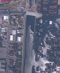 Breach in 17th Street Canal levee on August 31, showing the inundated Lakeview neighborhood on the right and the largely dry Metairie side on the left (NOAA)