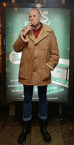 A German skinhead wearing a sheepskin coat and ranger boots
