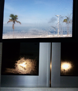 Condensation on the outside of a window, due to it being in front of the sea which regularly produces moist sea spray.