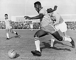 Pelé dribbling past a defender while playing for Brazil in May 1960