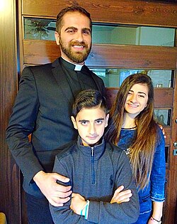 Lebanese Christian priest and his children in 2023.