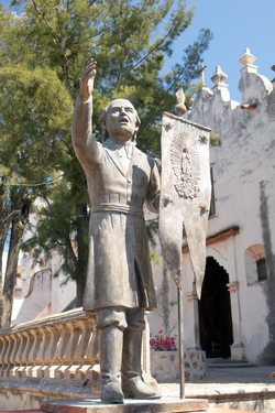 Father Miguel Hidalgo y Costilla with the movement's banner; statue at the Sanctuary of Atotonilco