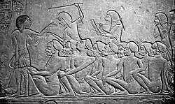 Kushite prisoners of war watched over by Egyptians, waiting to be deported into Egypt. Relief from the tomb of Horemheb in Saqqara.[28][29]