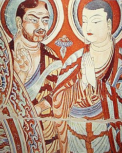 Central Asian Buddhist monk teaching a Chinese monk. Bezeklik, 9th–10th century; although Albert von Le Coq (1913) assumed the blue-eyed, red-haired monk was a Tocharian,[5] modern scholarship has identified similar Caucasian figures of the same cave temple (No. 9) as ethnic Sogdians,[6] an Eastern Iranian people who inhabited Turfan as an ethnic minority community during the phases of Tang Chinese (7th–8th century) and Uyghur rule (9th–13th century).[7]