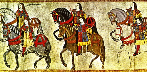 Officers of the College of Arms riding in procession to the Westminster Tournament, from a tourney roll, made during the reign of King Henry VIII in 1511. The pursuivants to the left are identified by their reversed tabards, while the figure in the right (with the black hat) is probably Garter King of Arms Sir Thomas Wriothesley.