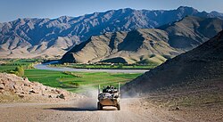 An Australian service light armored vehicle drives through Tangi Valley, 2011