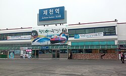 The sign with the name of the railway station in Jecheon — at the top, a writing in Hangul, the transcription in Latin script below using the Revised Romanization and the English translation of the word "station", along with the Hanja text