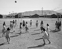 Japanese American women playing volleyball at the Manzanar internment camp during World War II in c. 1943
