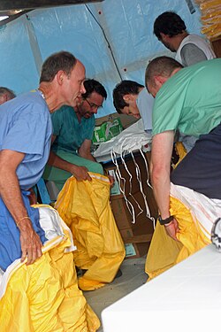 Doctors from MSF and the American CDC put on protective gear before entering an Ebola treatment ward in Liberia, August 2014.