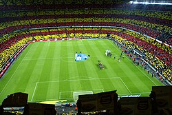 Camp Nou (before renovation), the home of FC Barcelona, before El Clásico. The fans of Barcelona are creating a mosaic of the Catalan flag.