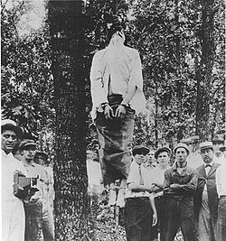 The lynching of Leo Frank in Marietta, Georgia, on August 17, 1915. Judge Morris, who organized the crowd after the lynching, is on the far right and he is wearing a straw hat.