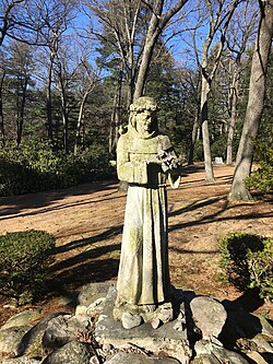 A garden statue of Francis of Assisi with birds