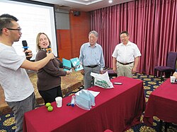 Lisa Moore, vice president of the Unicode Consortium, presenting Choijinzhab and Nashunwuritu with copies of the Unicode Standard at a meeting of ISO/IEC JTC 1/SC 2 in Hohhot, Inner Mongolia, in 2017