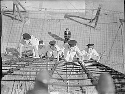 The Royal Navy during the Second World War. Six naval rating recruits of the training ship HMS Impregnable, Devonport, scramble up the rigging during a daily training exercise.