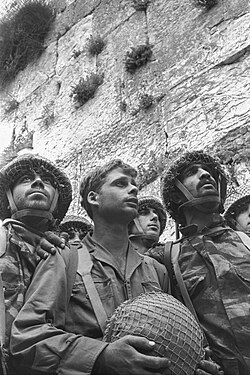David Rubinger's iconic photograph of IDF paratroopers at Jerusalem's Western Wall shortly after its capture. The soldiers in the foreground are (from left) Zion Karasenti, Yitzhak Yifat, and Haim Oshri.