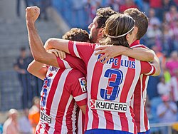 Atlético Madrid players celebrate a goal with a group hug.