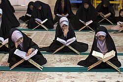 Shia Muslim girls reciting the Quran placed atop folding lecterns (rehal) during Ramadan in the city of Qom, Iran