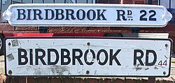 Street name signs on Birdbrook Road, Great Barr, Birmingham, showing old "Birmingham 22" postal district (top) and modern "B44" postcode.