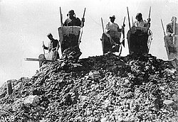 Workers being forced to haul rocks up a hill in a Gulag