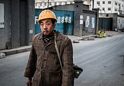 A Chinese migrant worker leaving the worksite after a shift in a city.